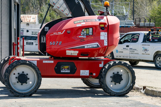 La Tuque, Quebec, 16 May 2026 : A red Manitou ATJ  boom lift is parked at a tool rental facility.