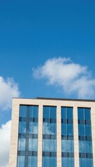 Fototapeta premium Modern Office Building Facade Under a Blue Sky