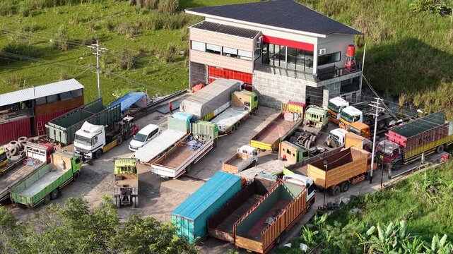 The logistics transport services office has many trucks parked in front of it, located near the port.