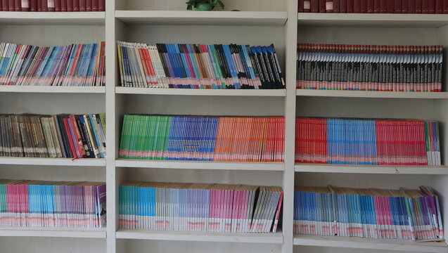 Malang, East Java, Indonesia &ndash; April 12, 2026: A photo of a neatly organized white bookshelf filled with colorful children's and educational books arranged by color; the setup evokes an atmosphere of 