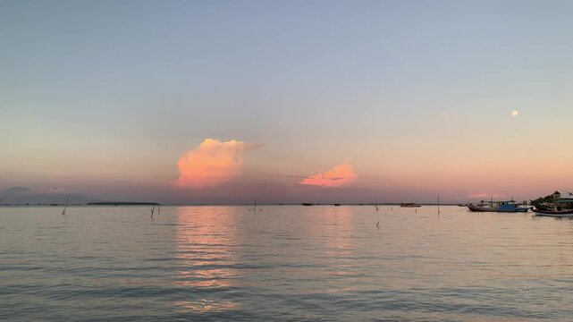 4K sunset seascape at Tanjung Lesung Beach, Banten, Indonesia, with island and fishing boat, calm reflections, and gentle rippling water sounds along the shore. Ideal for nature, wellness, relaxation,