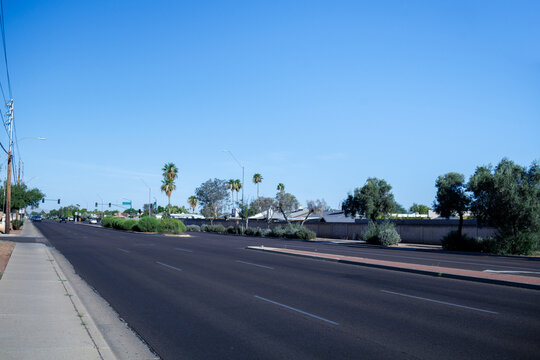 Morning traffic scene on Bell Road in Phoenix AZ with wide lanes, palm trees, clear sky, and open copy space