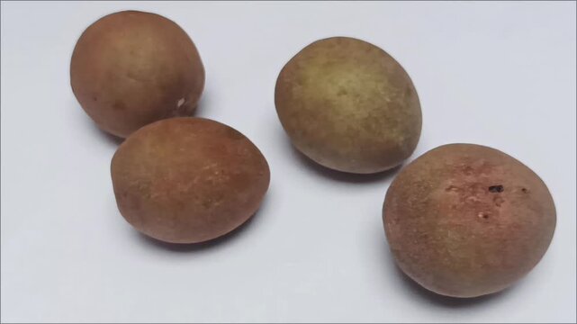 Close up of ripe brown sapodilla fruits or fresh chiku on clean white background.