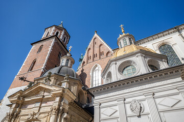 Obraz premium View of church towers and domes against clear blue sky in a historic city. Krakow cathedral stands tall against clear blue sky during bright daylight in Poland
