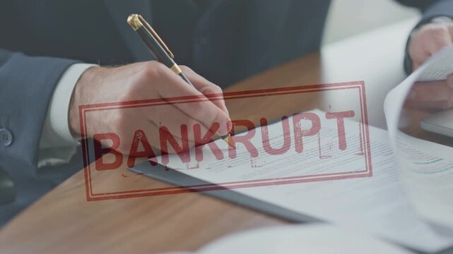 Close-up of a businessman signing a legal document overlaid with a red "BANKRUPT" stamp. The concept of business failure, financial ruin, filing for bankruptcy, and severe economic crisis.