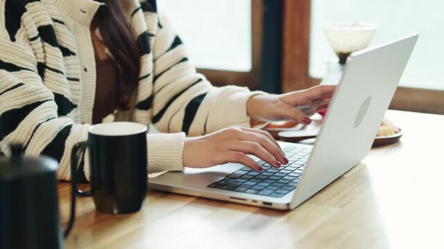 Woman Using Laptop at Home Kitchen Table with Coffee Mug in Cozy Casual Setting