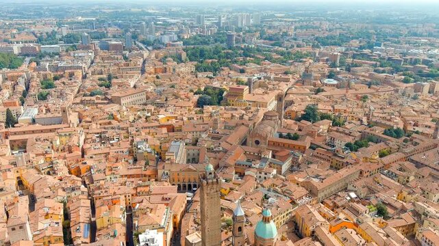 Bologna, Italy. The Two Towers, Asinelli and Garisenda, rise above a dense sea of terracotta rooftops in a sweeping summer Drone footage over the historic city center. Drone footage