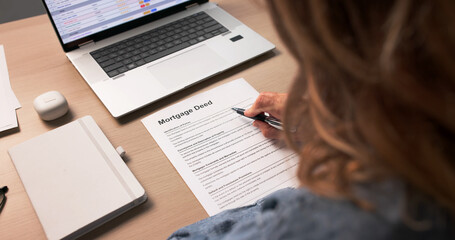 Obraz premium Woman Reviewing Important Mortgage Deed Document