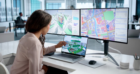 Young Woman Studies City Zoning Maps On Laptop