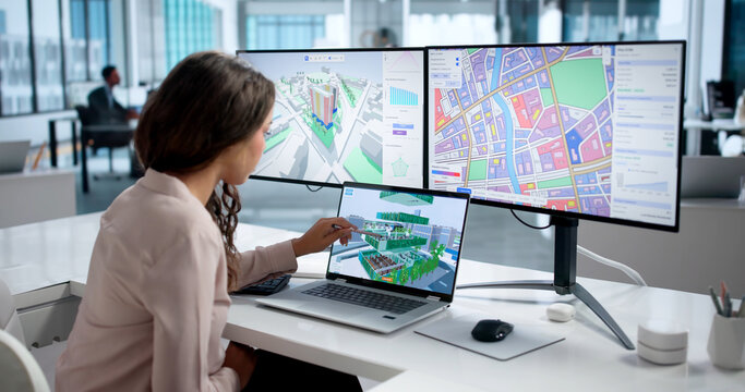 Young Woman Studies City Zoning Maps On Laptop