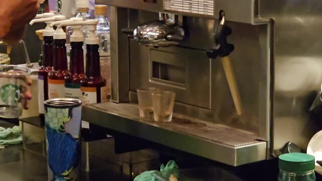 Barista preparing fresh espresso shots with a professional espresso machine on a scale, focusing on precise brewing in a modern coffee shop atmosphere