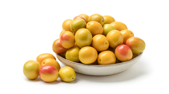 Bowl overflowing with ripe yellow and red plums and pluots on white background