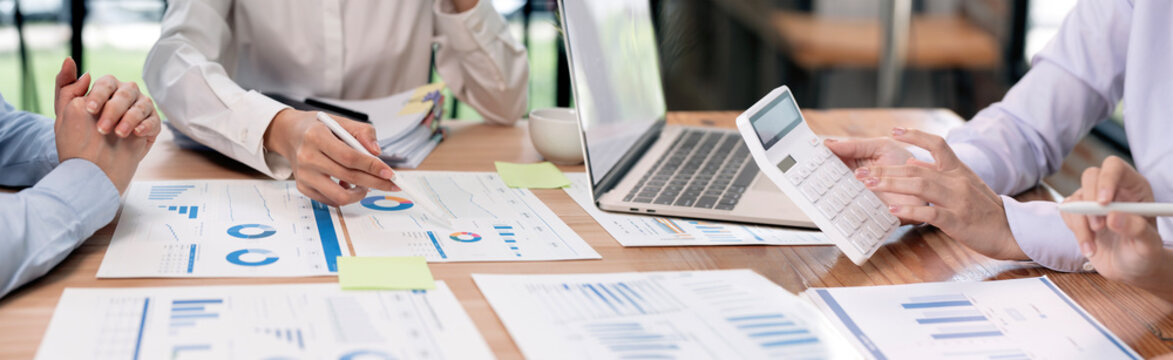 Business team analyzing financial charts on desk, panoramic banner.