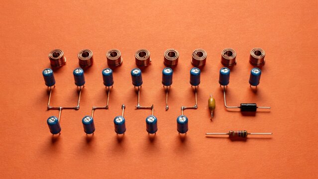 Electronic components arranged on an orange surface for inspection