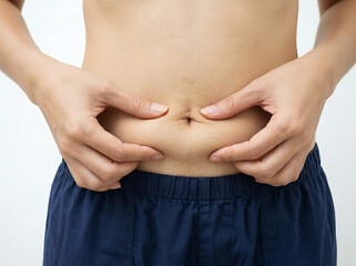 Naklejka premium Person pinching stomach fat showing belly skin texture hand