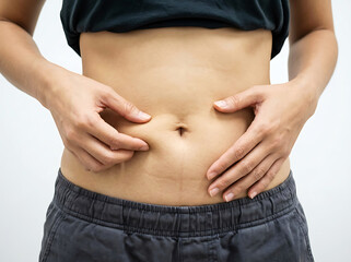 Naklejka premium Person pinching stomach skin with fingers on white background body