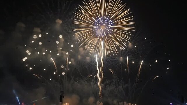 Spectacular colorful fireworks display grand finale over a cheering silhouetted crowd at night
