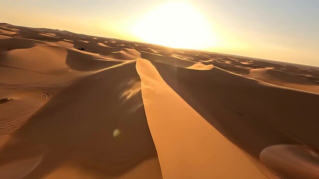 Golden sunset over vast sand dunes in the Sahara desert aerial view. Dramatic shadows reveal the textures of the arid landscape. Desert wilderness theme, ideal for travel and cinematic visuals.