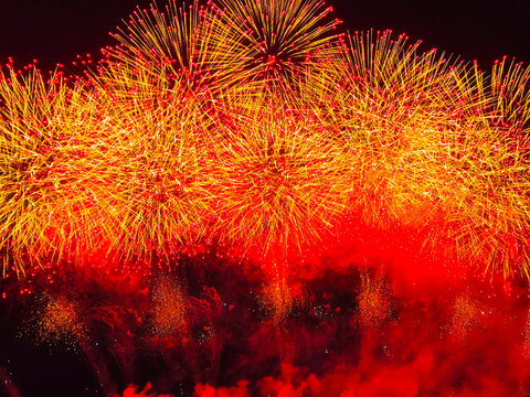 Spectacular golden and red fireworks exploding over the night sky at Omagari Fireworks Festival, Akita, Japan.