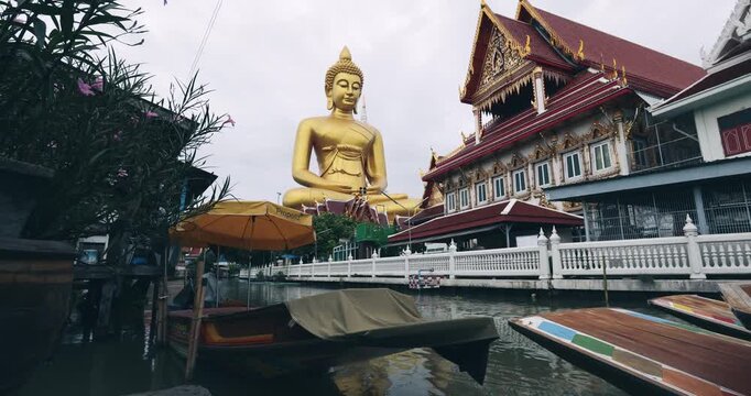 Big golden buddha statue at wat paknam phasi charoen with travel local wooden boat sightseeing travel in Bangkok Thailand