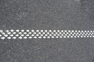 Fototapeta premium Close-Up of White Road Marking Made of Reflective Paint Dots on Asphalt