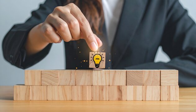 Business professional placing the final wooden block into a structure with a light bulb icon, symbolizing innovation, strategy, and problem solving.
