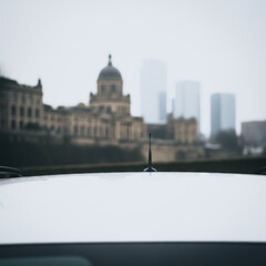 Naklejka premium White car roof and antenna with blurred cityscape background