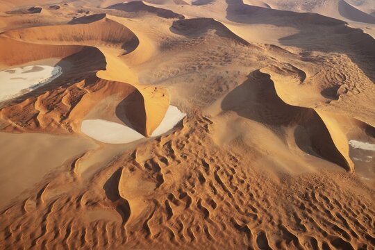 Sand dunes and dry pans in the Namib Desert. In the evening. Aerial view. Namib-Naukluft Park, Namibia