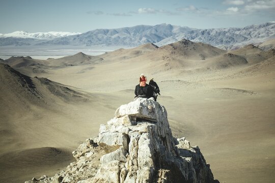 Eagle hunter Bashakhan spies with the eagle female Paimas in the valley for foxes, Kisil Czar, Olgii, Mongolia