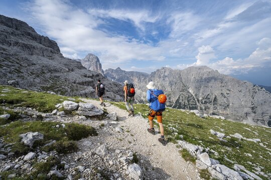 Three mountaineers on a hiking trail, rocky mountain landscape, Via Ferrata SOSAT via ferrata, Brenta Mountains, Trentino, Italy