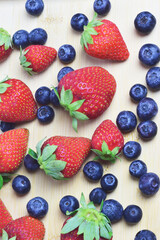 Obraz premium Vertical shot, strawberry and blueberries, zenith view.