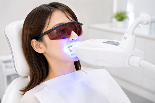 LEDライトでホワイトニング施術を受ける女性

