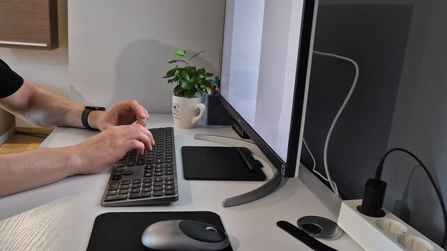 Hands using graphic tablet, mouse and keyboard in front of computer monitor