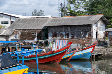 Obraz premium Colorful traditional wooden fishing boats moored along a village harbor in Cilacap, Indonesia.