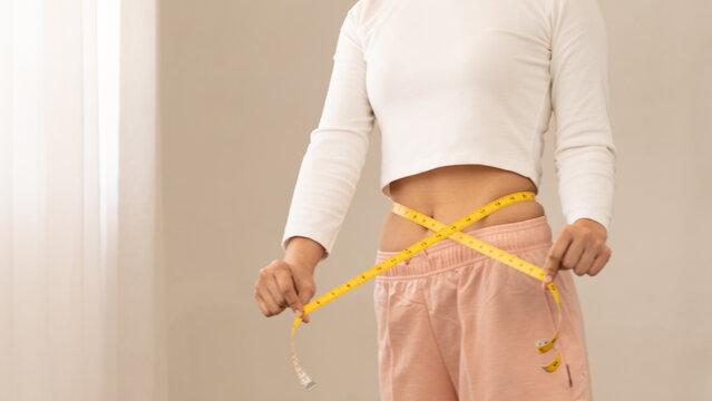 woman measuring waist with yellow tape at home, weight loss and fitness concept, body shape control, healthy lifestyle, diet progress. weight, loss, fitness, waist, measuring, tape, body, shape, slim