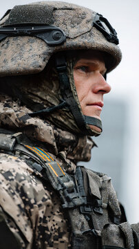 Soldier in camouflaged uniform and helmet, focused expression