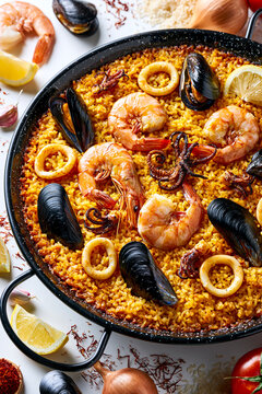 Seafood paella in pan with shrimp, mussel and lemon