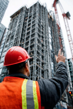 Construction worker signaling at high rise building site