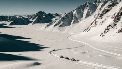 Aerial view of snow mobiles traveling across a snowy arctic tundra in the high mountains on a cold winters day.  © pinan