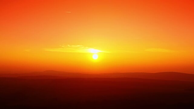 Golden sunset over layered mountain hills. Warm orange and yellow gradient sky with sun disc touching the horizon silhouette.
