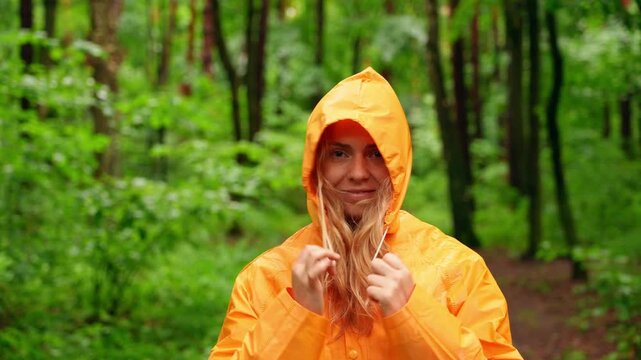 Person in bright raincoat in rainy forest on trail