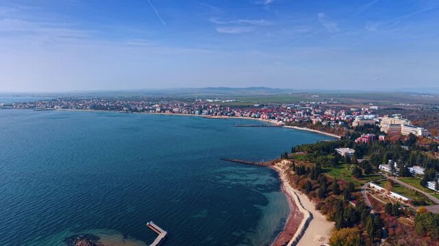 Aerial view of Black Sea coastline near Nessebar, Bulgaria. Drone perspective of turquoise water, sandy beaches, resort buildings and green parkland.