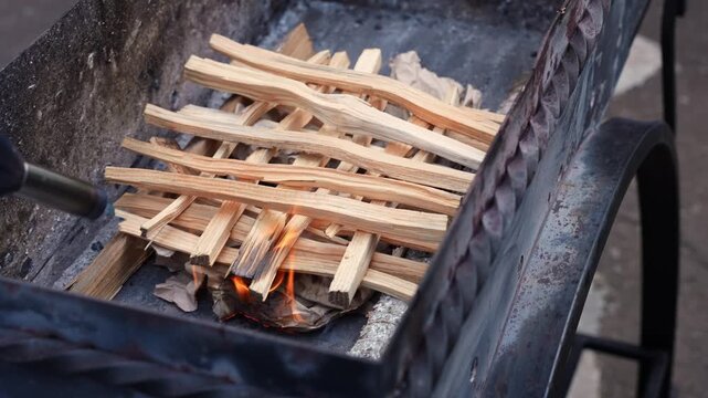 Close-up of lighting wood fire in outdoor barbecue grill