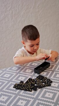 Young boy developing motor skills with dominoes