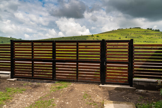 New painted pine wood horizontal fence, main gate  with 1 inch gaps between the pine boards.