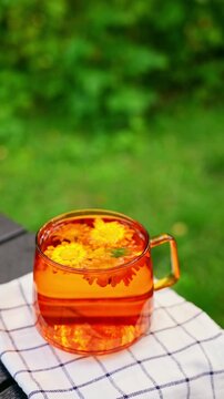 Calming calendula detox tea in glass mug outdoors