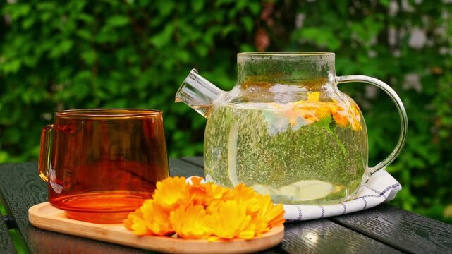 Calendula tea in glass teapot for calming detox ritual