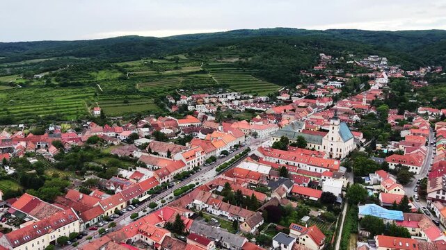 Drone footage of the historic town of Svaty Jur surrounded by vineyards and rolling hills of the Little Carpathians in western Slovakia.