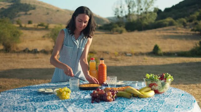 Woman serving Spanish tortilla and gazpacho picnic