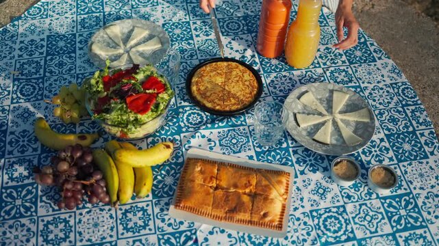 Woman preparing summer picnic with tortilla and gazpacho